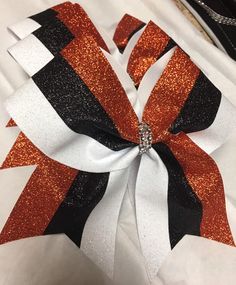 "Orange, white, and black glitter cheer bow. Made with 3\" ribbon. Bow measures approx. 6.5\"x6.5\" Cheer bow comes with a hair tie. I do not manufacture hair ties, therefore do not warrant them. Orders are processed once payment is received, not when a request is made in a message." Cheer Costumes, Cheer Pom Poms, Glitter Cheer Bow, Blue Cheer, Fitness Board, Cheerleading Bows, Cheer Outfits, Cheer Uniform, Cheer Gifts