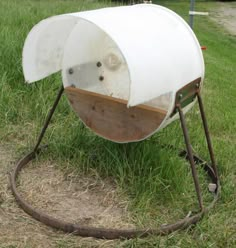 a white toilet sitting on top of a metal stand in the middle of some grass