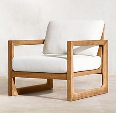 a white chair sitting on top of a hard wood floor next to a cement wall