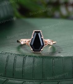 a black stone ring sitting on top of a green surface