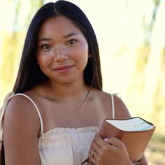 a woman is holding a bowl and looking at the camera