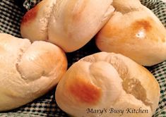 four loaves of bread sitting on top of a checkered cloth