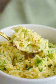 broccoli and rice in a white bowl with a spoon sticking out of it