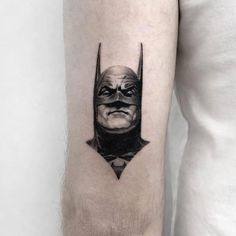 a man with a batman tattoo on his arm