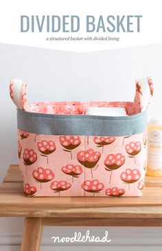 a pink basket sitting on top of a wooden table