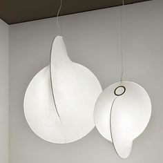 two white lamps hanging from the ceiling in a room