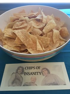 a bowl filled with chips sitting on top of a table next to a sign that says chips of inanity