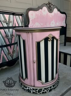 a pink and black striped cabinet sitting on top of a table