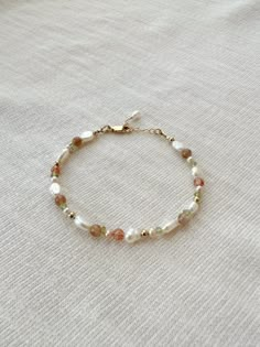 "Please review the bracelet sizing guide below for the perfect fit! This mixed gemstone and pearl beaded bracelet makes a lovely addition to your bracelet stack! The genuine moonstone, sunstone, peridot, and pink pearls are accented by creamy white pearls. Each bracelet is hand beaded to order 🫶🏻 * 2-9mm mixed natural Gemstones and Pearls * 14K Gold Filled or 925 Sterling Silver accents * 14/20 GF 925 stamp for authenticity * Made with all hypoallergenic materials 🤍 * Choose your length. Each bracelet comes with a 1\" extender chain for adjustable sizing. Bracelet Sizing Guide: 5-6.5 inches = xtra small 6.5-7 inches = small 7-8 inches = medium 8 inches+ = large Each Bracelet is measured held taught from tip to end. Unsure what size to choose? The best way to find the right size is to ta Dainty Pearl Beaded Bracelets With Gold Beads, Dainty Pearl Beaded Bracelets, Dainty Beaded Bracelets, Cute Adjustable Pearl Bracelet With Colorful Beads, Dainty Yellow Gold Pearl Beaded Bracelets, Pearl Beaded Bracelet, Dainty Pearl Bracelet With Colorful Beads, Diy Pearl Bracelet, Beaded Bracelet Stack