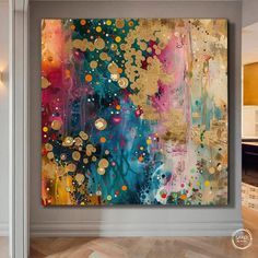 an abstract painting is hanging on the wall