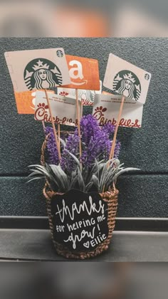 a basket filled with purple flowers sitting on top of a counter next to a starbucks sign