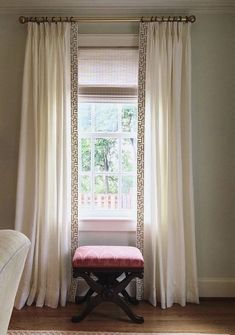 a window with curtains and a bench in front of it