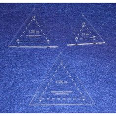 three clear triangulars on a blue surface with one smaller triangle in the middle and two smaller triangles at the bottom