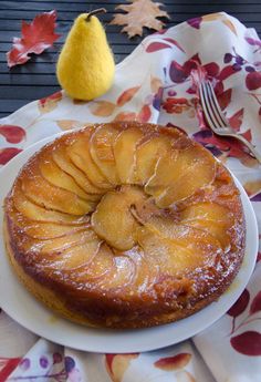 a pineapple upside down cake on a plate with a fork and knife next to it