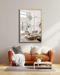 a living room with a couch, coffee table and large mirror hanging on the wall