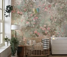 a baby crib in front of a floral wallpaper with pink roses on it