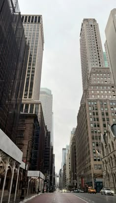 an empty city street with tall buildings in the background