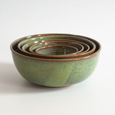 four green ceramic bowls stacked on top of each other