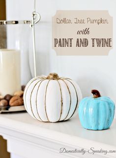 two painted pumpkins sitting on top of a white mantle next to a candle holder