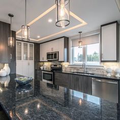 a kitchen with marble counter tops and stainless steel appliances, along with an island in the middle