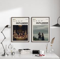 two movie posters hanging on the wall above a desk with a lamp and other items