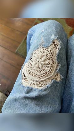 someone is wearing jeans with crochet on them