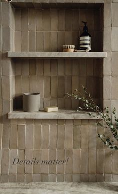 two shelves with vases and cups on them in a tiled bathroom area that reads details matter