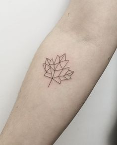 a small leaf tattoo on the left forearm and arm, it looks like an origami piece