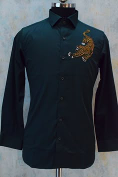 Olive green designer partywear shirt made in cotton fabric with a magnificent jaguar motive on the front side hand embroidered with fine detailing. This designer shirt is one of the best choice for cocktail parties.  Components : 1 Fabric : Giza Cotton Neckline : Straight Collar Other Details : Hand Embroidery (Cutdana Work)  Cuff : Barrel Cuff (French cuff could also be made on request) Color : Olive Green Embroidery On Mens Kurta, Festive Fitted Embroidered Shirt, Festive Embroidered Fitted Shirt, Luxury Embroidered Cotton Tops, Formal Festive Embroidered Shirt, Festive Formal Embroidered Shirt, Festive Fitted Shirt For Semi-formal Occasions, Festive Fitted Semi-formal Shirt, Embroidered Fitted Shirt For Formal Occasions