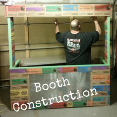 a man standing in front of a booth that says booth construction