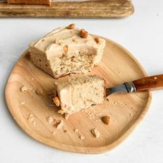 a piece of cake on a wooden plate with a knife