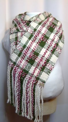 a white mannequin head wearing a red and green plaid scarf