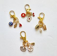 four different types of keychains with charms attached to them on a white surface