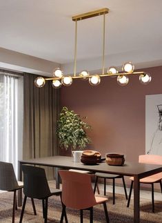 a dining room table and chairs with lights hanging from the ceiling