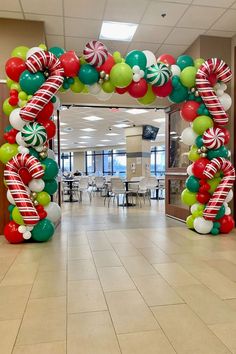 an arch made out of balloons and candy canes in the middle of a room