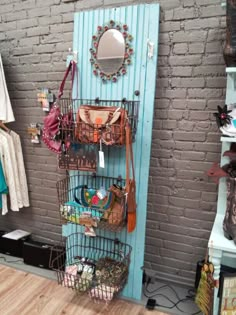 there is a rack with purses on it in the room next to a brick wall