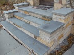 a set of stone steps leading up to a door with a fire place in the middle