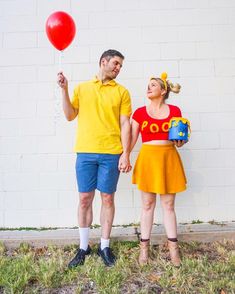 a man and woman dressed in costumes holding balloons