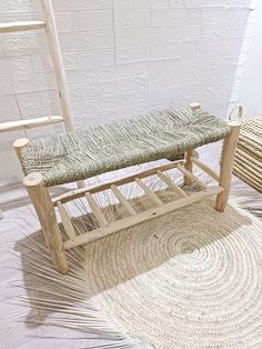 a wooden bench sitting on top of a rug next to a chair with a woven seat