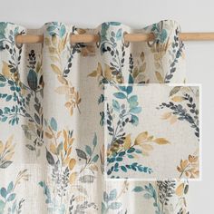 the curtains are hanging up in front of a white wall with blue and yellow leaves