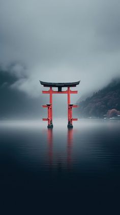 a large red gate sitting in the middle of a body of water