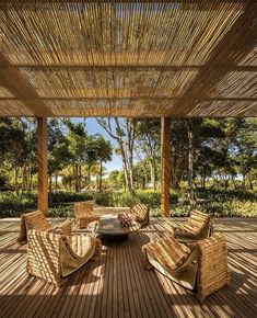 an outdoor living area with wicker furniture and trees in the backgroung