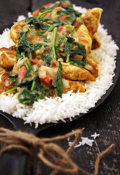 chicken with spinach and white rice on a plate