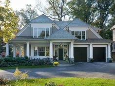 a large house with two garages in front of it