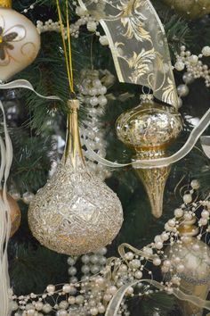 ornaments are hanging on the christmas tree in gold and silver colors, including baubles