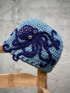 a crocheted octopus hat sitting on top of a wooden chair