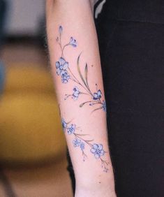 a woman's arm with blue flowers on it