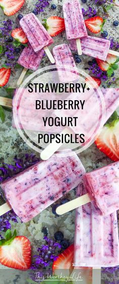 strawberry blueberry yogurt popsicles with strawberries and lavenders in the background