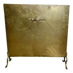 an antique brass plate with two handles on each side and a diamond in the middle