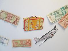 an assortment of different types of money and scissors on a white surface with magnets attached to it